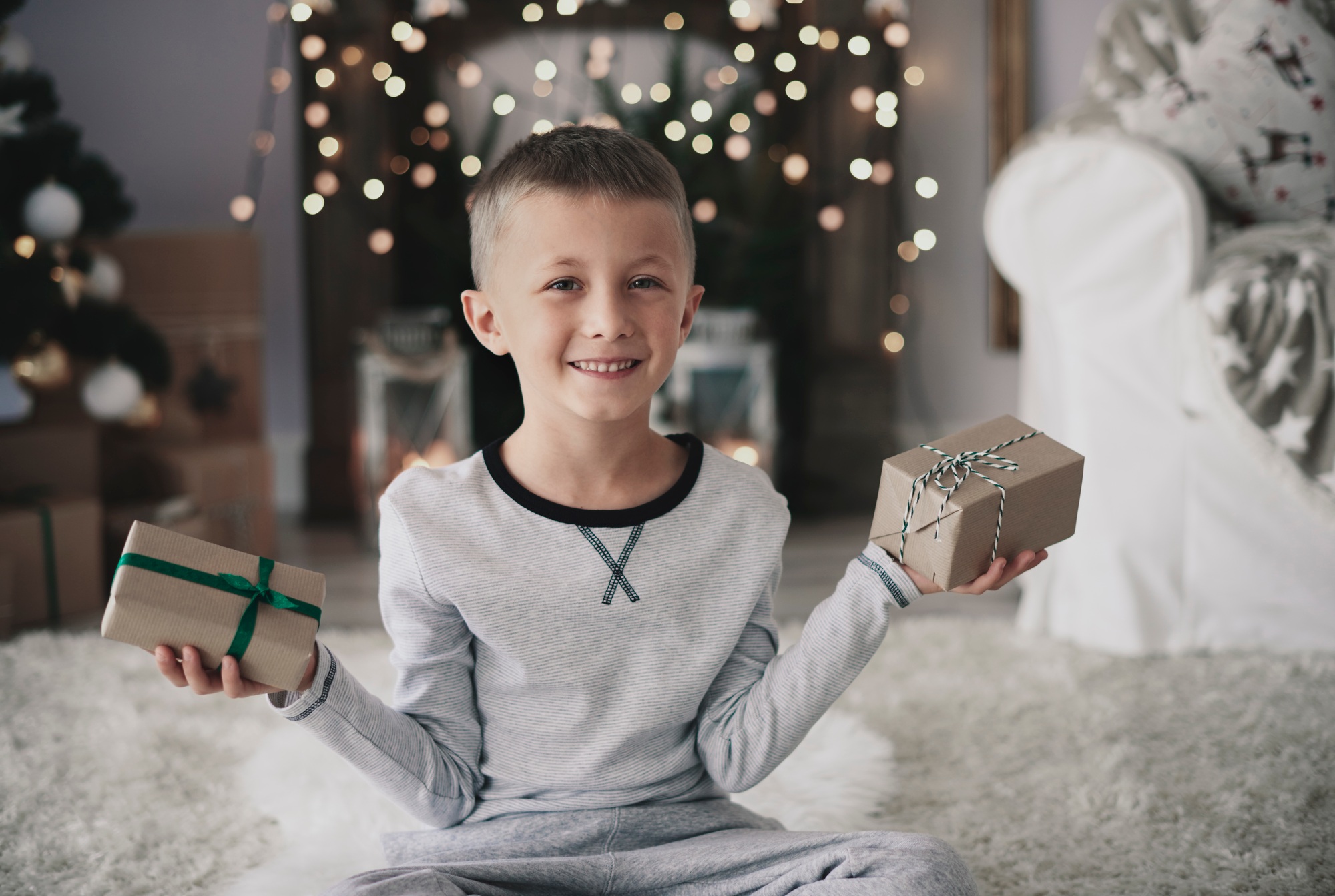 Cute boy with gifts looking at camera
