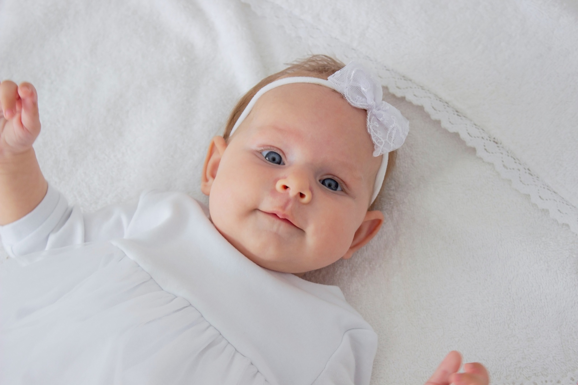 A little girl and a cross. Baptism of a child.