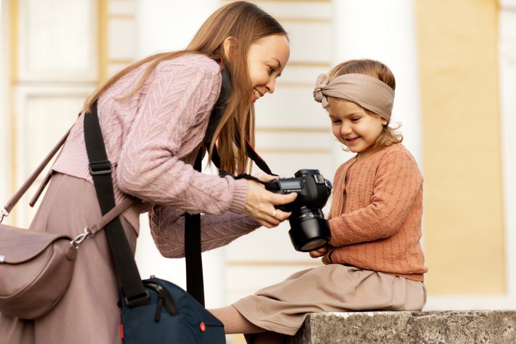 the photographer shows the photos taken to the child on the camera during a photo shoot