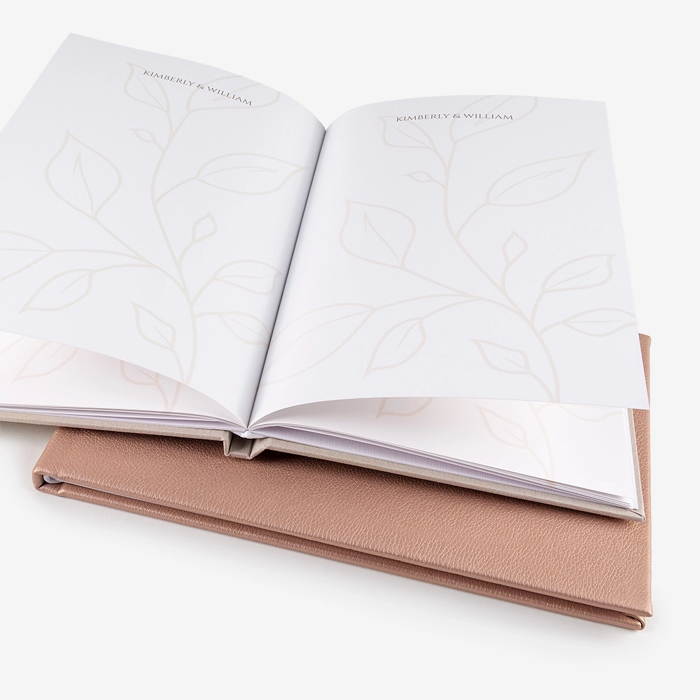 Celebra tu boda con un Libro de Firmas Personalizado, diseñado para conservar los mensajes y deseos más emotivos de tus invitados. Elige entre una portada con nombres o fotografía, distintos revestimientos en Buckram y un acabado Basic con papel True White. Un recuerdo elegante, duradero y completamente único.