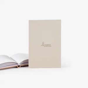 Celebra tu boda con un Libro de Firmas Personalizado, diseñado para conservar los mensajes y deseos más emotivos de tus invitados. Elige entre una portada con nombres o fotografía, distintos revestimientos en Buckram y un acabado Basic con papel True White. Un recuerdo elegante, duradero y completamente único.