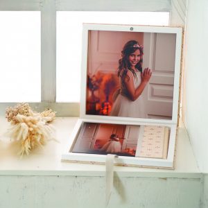 Descubre nuestra caja premium de madera forrada con portada interior personalizada. Elige materiales, tipografía y texto para la ventana. Acabado en blanco puro. Tamaños 30x30 y 40x30 cm. La presentación definitiva para tu álbum.