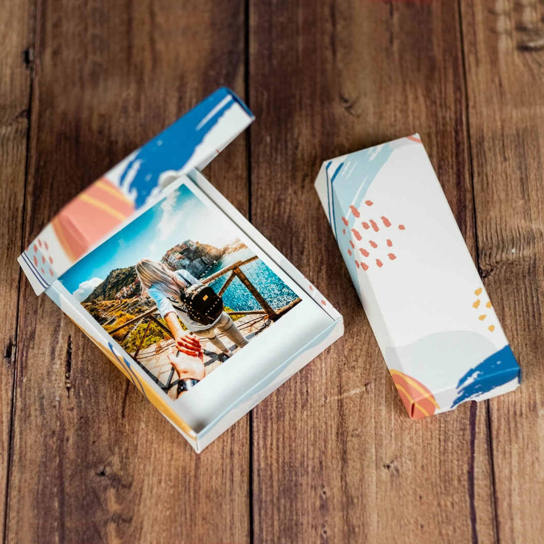 Revive la magia de la fotografía analógica. Fotos vintage con bordes blancos en 4 formatos clásicos: Square, Polaroid, Instax Mini y Fotostrip. Incluye elegante caja de presentación. El regalo nostálgico perfecto.