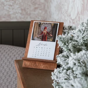 Calendario de escritorio personalizado con soporte de madera nogal o acrílico transparente. 6 hojas a doble cara con 12 fotos, papel True White Mate. Formato 10x15 cm. Regalo funcional y emotivo para clientes y espacios de trabajo.